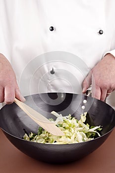 Female chef and cabbage in a wok