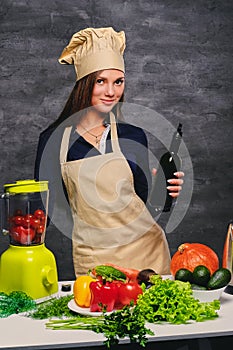 Female chef cook holds bottle with oil.