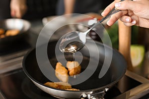 Female chef cooking in restaurant kitchen, closeup