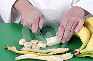 Female chef cutting a banana