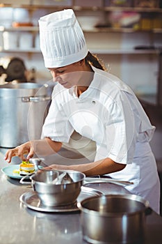 Female chef finishing dessert plates