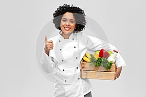 female chef with food in box showing thumbs up
