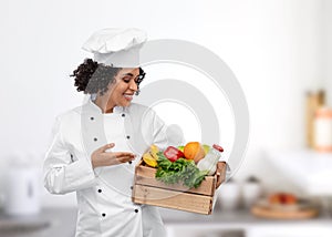 female chef with food in wooden box in kitchen