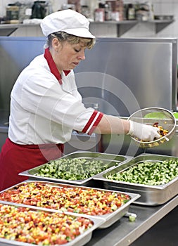 Female chef making salad