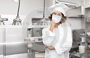 Female chef in mask at restaurant kitchen