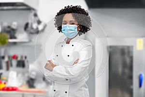 female chef in medical mask and jacket on kitchen