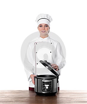 Female chef with modern multi cooker at table