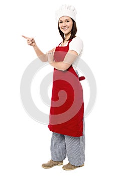 Female chef pointing towards copy space area