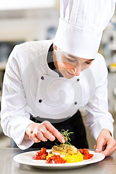 Female Chef in restaurant kitchen cooking