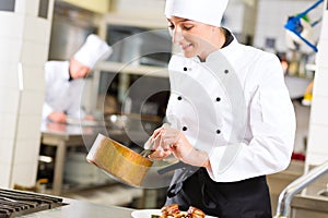 Female Chef in restaurant kitchen cooking