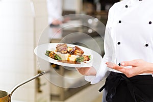 Female Chef in restaurant kitchen cooking