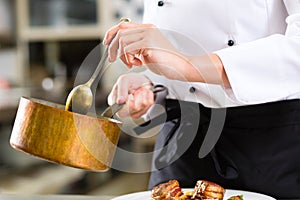 Žena šéfkuchár v reštaurácia kuchyňa varenie 
