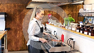 Female chef in restaurant or new small business kitchen cooking delicious food on modern electric stove