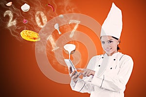 Female chef is searching recipe with smartphone