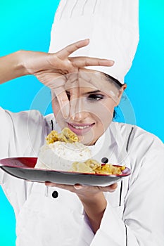 Female chef sprinkling spices on a dish