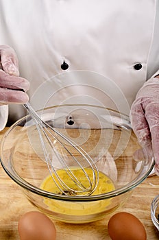 Female chef stirring an egg, oil and vinegar