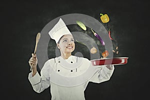 Female chef throws food ingredients in a frying pan