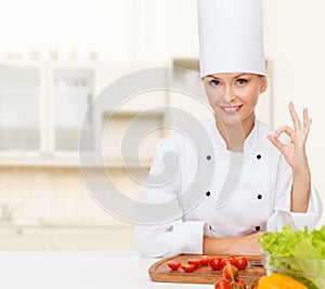 Female chef with vegetables showing ok sign