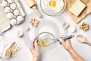 Female chef whisking eggs in glass bowl on kitchen table