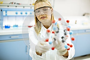 Female chemist hold molecular model in the lab