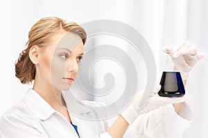 Female chemist holding bulb with chemicals