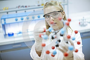 Female chemist hold molecular model in the lab