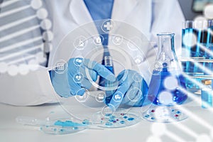 Female chemist scientist holding test tube and tablet conducting experiment in laboratory with equipment, science concept