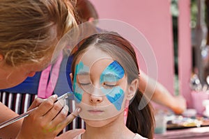 Female child face painting, making butterfly process