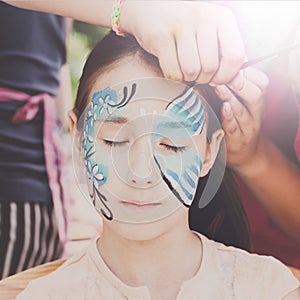 Female child face painting, making butterfly process