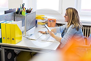 Female child therapist in an office during a phone call, using online calendar to schedule patients appointments. Calendar Planner