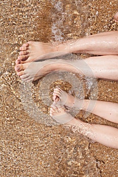 female and childish feet on the sand. rest and sea air. family vacation