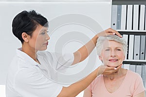 Female chiropractor doing neck adjustment