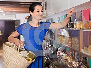 Female is choosing sweet dry fruits