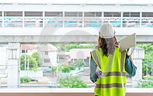 Female Civil engineer working on tranportation development in the background