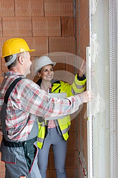 Female civil engineering and worker check a concrete wall