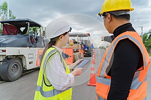 Female civil engineers consult with or with contractors to build rural roads using online technology