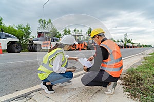 Female civil engineers consult with or with contractors to build rural roads using online technology