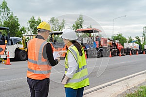 Female civil engineers consult with or with contractors to build rural roads using online technology