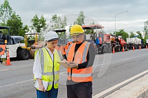 Female civil engineers consult with or with contractors to build rural roads using online technology