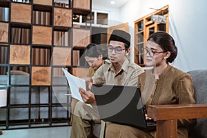 female civil servants use laptop computers and male civil servants hold worksheets