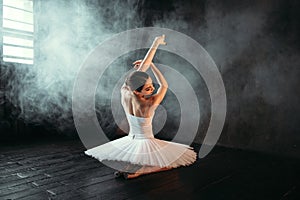 Female classical ballet performer sitting on floor