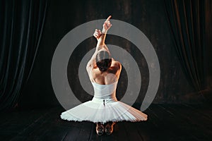 Female classical ballet performer sitting on floor