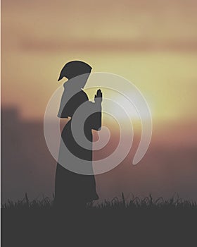 A Female Clergy Praying Under The Sunset photo