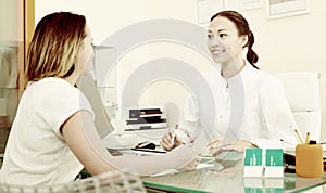 Female client consulting smiling doctor in medicine center