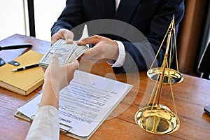 A female client gives a bribe to her lawyer in the office. cropped image