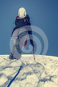 Female climber ascending a snowy slope.