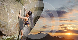Female climber climbing big boulder in nature with rope