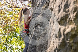 Female climbing the rock wall of the mountain