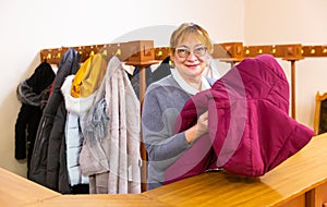 Female cloakroom attendant gives out clothes at cinema