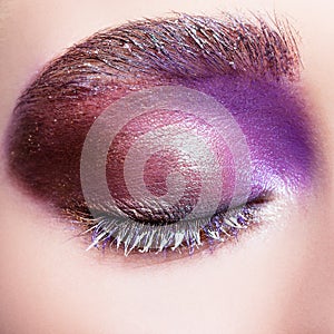 Female closed eye with evening violet purple eyes shadows and white eyelashes makeup